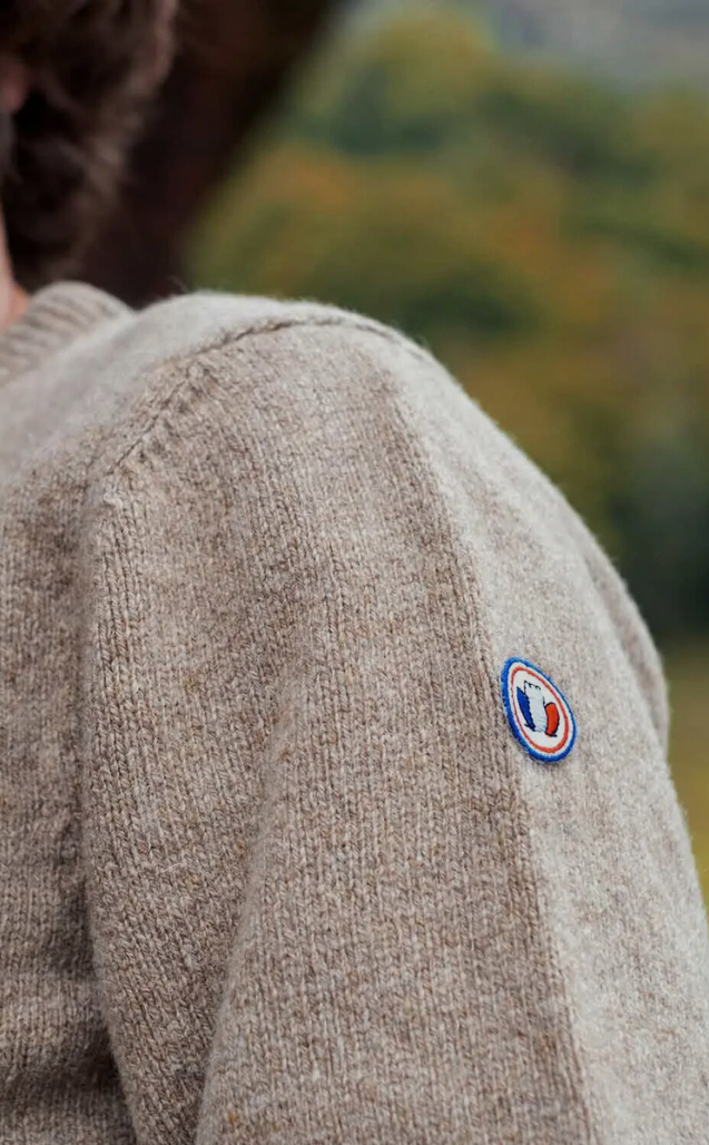 Détail d’une maille bleu marine et de son étiquette tricolore